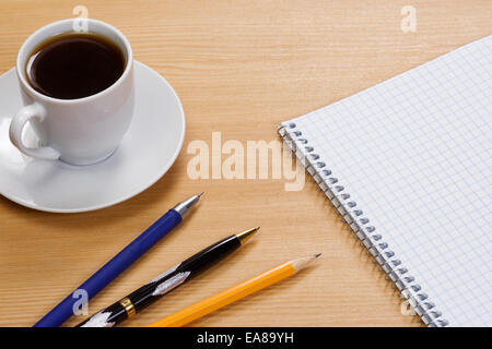 coffee, notepad and pens on table Stock Photo