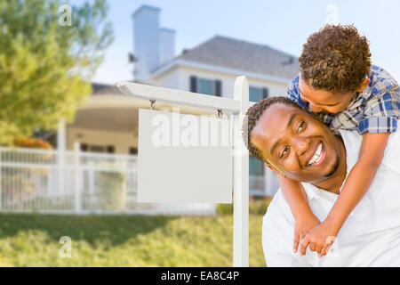 Happy African American Father and Mixed Race Son In Front of Blank Real Estate Sign and New House. Stock Photo