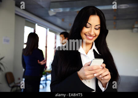 Smiling businesswoman using smartphone Stock Photo