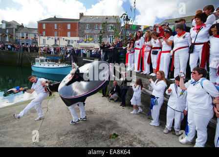 Crowds of people around the harbour watching the Oss & Teaser dancing on the slipway near the waters edge in Padstow on the firs Stock Photo