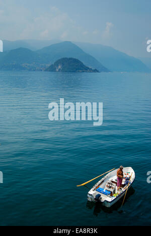 man fishing from rowing boat near Bellagio on Lake Como in northern Italy Stock Photo