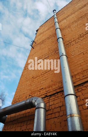 two ventilation pipes on a brick yellow wall Stock Photo