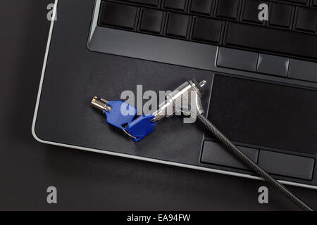 Computer with lock and key, light on main part of lock, on black background Stock Photo