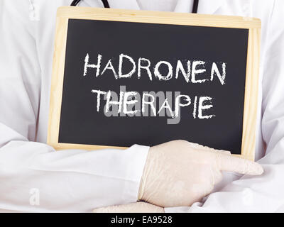 Doctor shows information: hadron therapy in german language Stock Photo