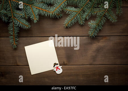 Christmas decoration. Blank scroll for text between fir twigs on dark Stock Photo