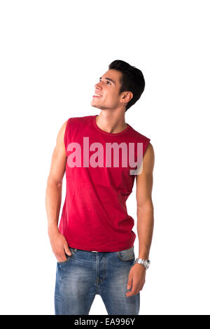 Attractive happy smiling young man in red sleeveless shirt and jeans, looking up, isolated on white Stock Photo