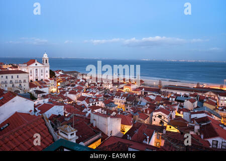 City of Lisbon in the evening in Portugal. View over old Alfama district along Tagus river. Stock Photo
