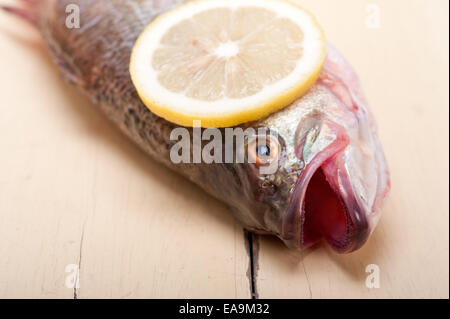 fresh whole raw fish on a wooden table ready to cook Stock Photo