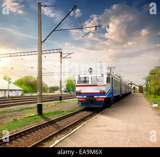 Train on the railway station at the sunset Stock Photo