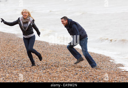 A couple enjoying a day out at the British seaside in Brighton in warm winter clothing Stock Photo