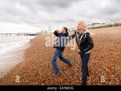A couple enjoying a day out at the British seaside in Brighton in warm winter clothing Stock Photo