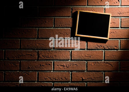 the blank blackboard hanging on brick wall Stock Photo