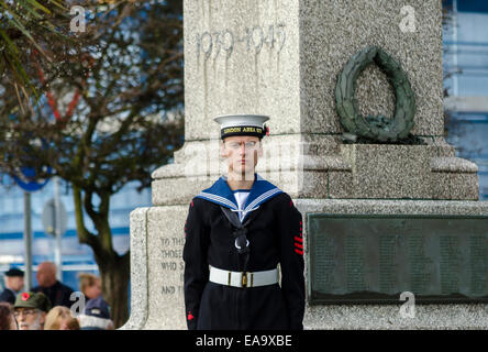 A young sailor standing to attention at a war monument England UK Stock Photo