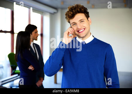 Happy businessman talking on the phone in office Stock Photo