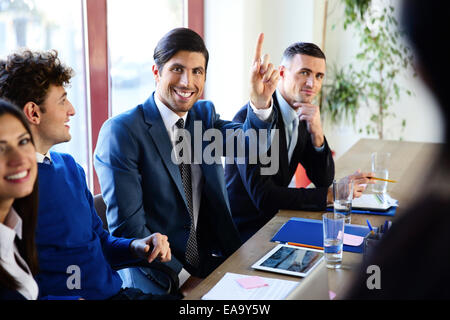 Happy businesspeople sitting at the table in a meeting Stock Photo