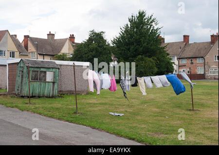 Laundry hanging on clotheslines in a residential backyard with brick terraced houses in the background Stock Photo