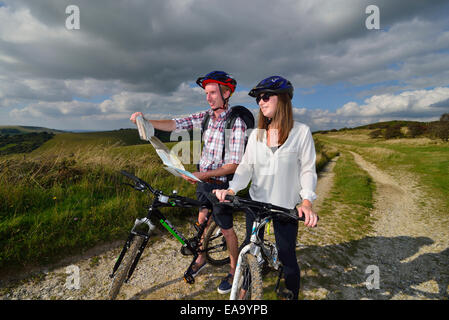 A young adult couple cycling along the South Downs Way at Butts Brow, Willingdon, near Eastbourne, East Sussex. UK Stock Photo