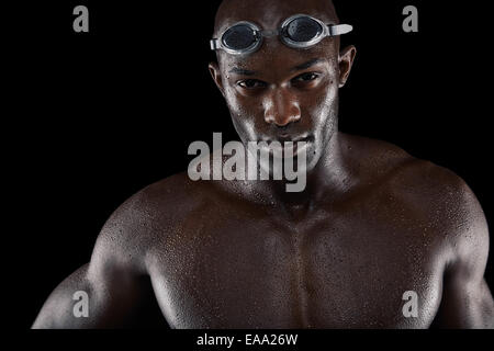 Studio shot of a handsome swimmer against a black background