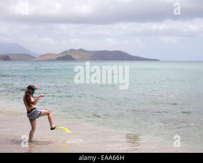 girl in snorkel gear walks towards sea Stock Photo