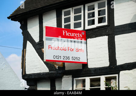 Estate agent for sale sign on a half timbered house in Claverley, Shropshire, England, UK Stock Photo