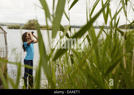 A young girl, a birdwatcher with binoculars. Stock Photo