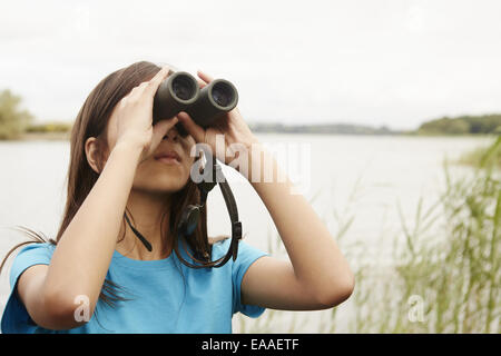 A young girl, a birdwatcher with binoculars. Stock Photo