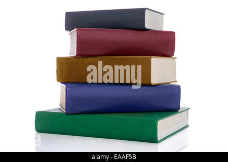 A stack of five hardback reference books with blank spines isolated on a white background. Stock Photo
