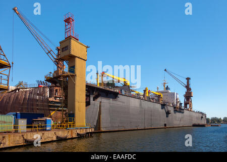 Dry floating dock and cranes in shipyard. Stock Photo