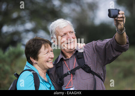 A mature couple taking a selfy photograph while out walking. Stock Photo