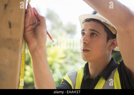 Construction worker wearing high visibility vest and safety helmet. Stock Photo