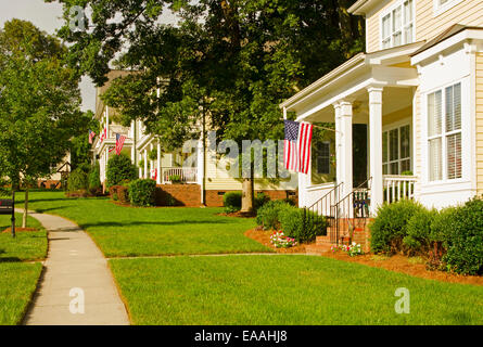 American Flags hang from front porches in a neighborhood of upscale, Victorian homes in celebration of the upcoming holiday. Stock Photo