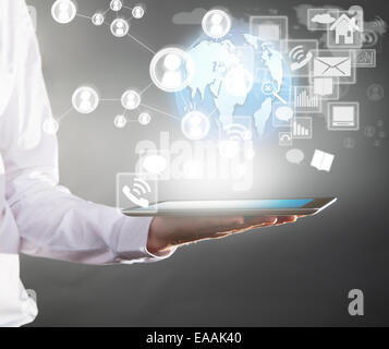 Business concept with manager holding tablet. Virtual icons around Stock Photo