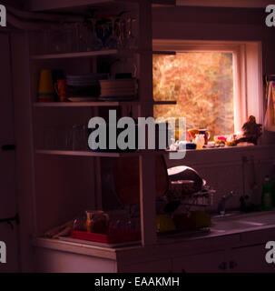 Interior of old Maine coastal home. Dark inside, warm sunlit landscape out large bay window. Stock Photo