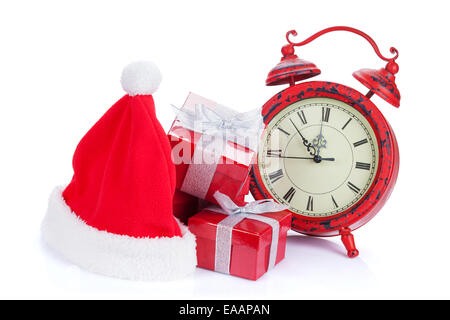 Christmas clock, gift boxes and santa hat. Isolated on white background Stock Photo