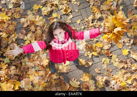 girl with hand up in autumn park Stock Photo