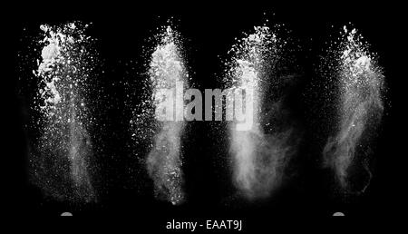 Freeze motion of white dust explosions isolated on black background Stock Photo