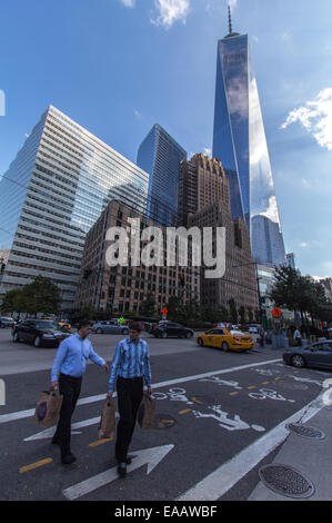 One Wold Trade Centre with surrounding buildings and pedestrians crossing Stock Photo