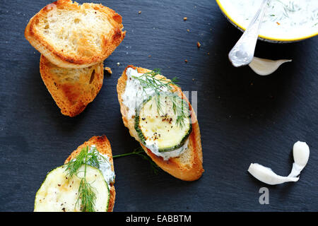 bruschetta and slices of baked baguette on slate, food Stock Photo