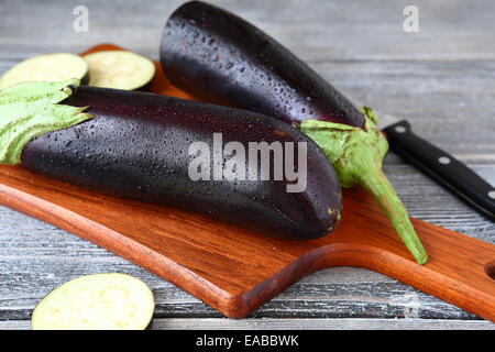 Raw aubergines on a cutting board, fresh vegetable Stock Photo