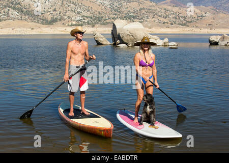 An elderly couple on stand on paddle boards on Lake Isabella near Bakersfield, East of California's Central valley which is at less than 13% capacity following the four year long devastating drought. The reservoir has dropped so low, that the water level is below the outflow pipe. Stock Photo