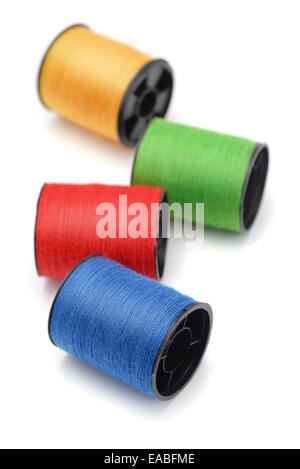 Four bobbins of color thread isolated on white Stock Photo