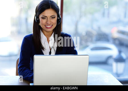 Cheerful beautiful call-center assistant at the desk Stock Photo