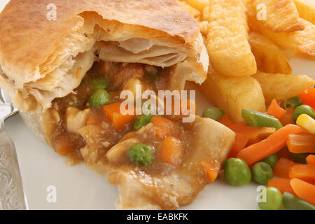 Chicken and vegetable pie with mixed vegetables and chips Stock Photo