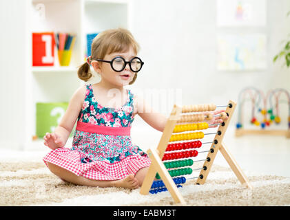 child kid weared glasses playing with abacus toy Stock Photo