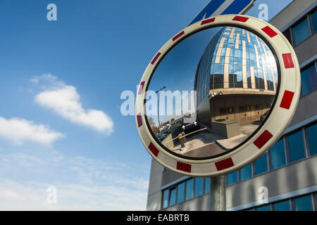 Convex mirror at a street reflecting a barrier entrance in underground garage Stock Photo