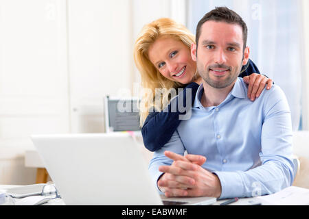 View of a Young attractive couple using laptop Stock Photo