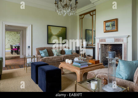 Large antique mirrors in airy sitting room with fireplace and pair of Kingscome sofas upholstered in taupe linen velvet from Lew Stock Photo
