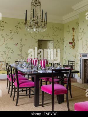 de Gournay Chinoiserie wallpaper in dining room with French crystal chandelier and dining chairs upholstered in Bruno Triplet ve Stock Photo