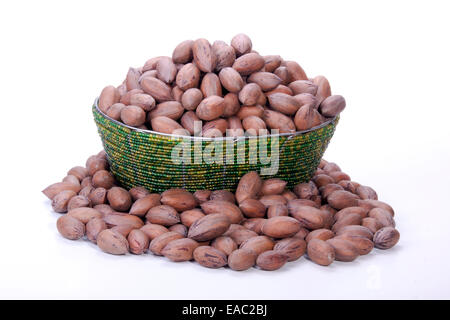 pile of unshelled pecan nuts in beaded Zulu basket Stock Photo