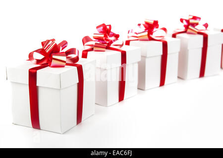 White gift boxes with red ribbons and bows on gray Stock Photo